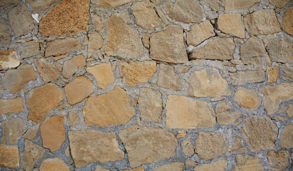 Texture background old stone wall. Wall texture of ancient old brick stone. Outdoor exterior castle facade with destroyed uneven pattern of shabby rock.