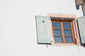 Window and shutter with a heart. White wall, free space. Details. Colmar, France
