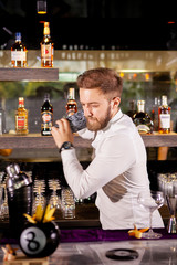 The bartender prepares a cocktail in the
