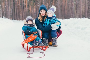 Mom with two children in a winter park