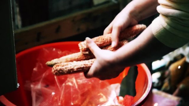 The woman cleans the remnants of the corn cob in a bowl