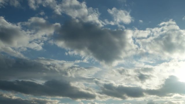 White and gray clouds floating on blue sky in the sun, time lapse        