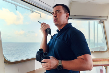 Portrait of navigator / pilot / officer on the bridge of the vessel