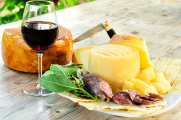 Vassoio di pecorino, pane carasau, vino cannonau e salame, cibo dalla Sardegna