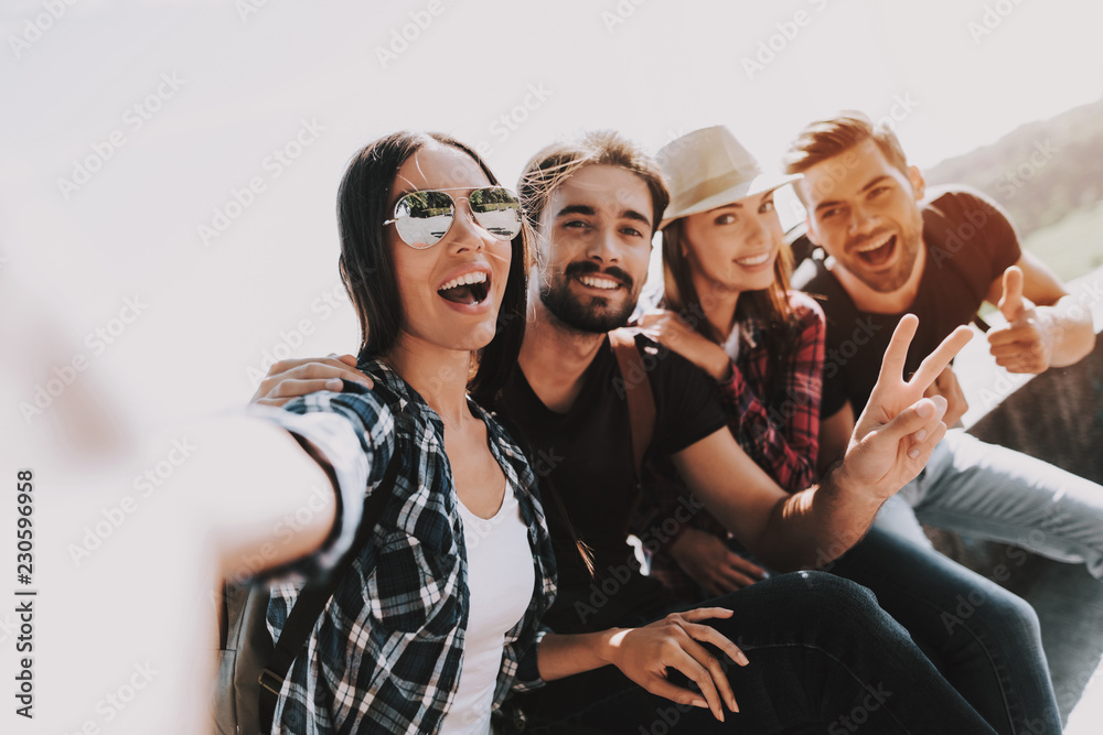 Wall mural Young Smiling People Sitting in Park taking Selfie