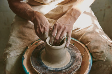 close up view of male potter hands working on pottery wheel at workshop - Powered by Adobe