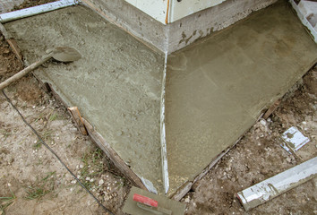 Workers pour concrete solution at a construction site