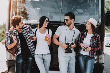 Young People Drinking Coffe in front of Tour Bus