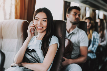 Smiling Woman Talking on Phone in Tourist Bus