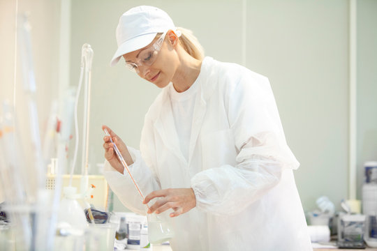 Female lab worker doing tests in a laboratory in an industrial cheese production factory