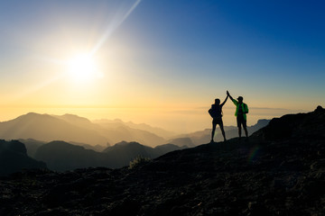 Couple hikers celebrating success concept in mountains - obrazy, fototapety, plakaty