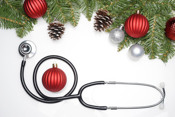Celebrating Christmas in the healthcare industry. Top view of flat lay. Stethoscope with ornaments...