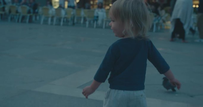 Toddler chasing pigeons in Venice