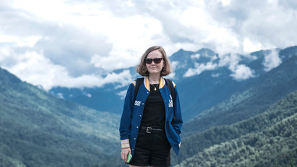 Naklejka premium Young girl on a background of mountains.