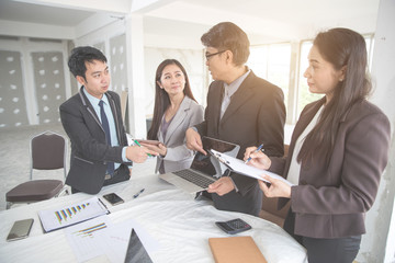 businesspeople meeting and discussing with graph and chart and showing successful result, and secretary making note using as background (concept of successful and achievement)