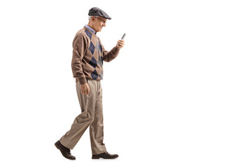 Senior man walking and using a mobile phone