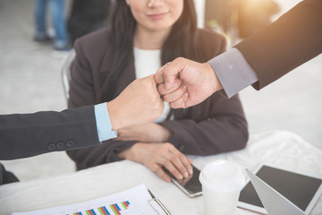 business people giving first bump after completed project during meeting using as background (concept of teamwork and partnership)