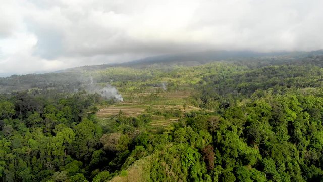 Aerial view of Rinjani volcano, surrounded by clouds in the island ok Lombok, Indonesia. Shot from Senaru town.