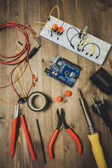 Workplace With Tools: Breadboard, Push Button, Resistors, Tweezers, Nippers, Soldering Iron, Wires, Microcircuit, Lamp Socket. Electronics Repair Service. Concept of Electronics, Programming.
