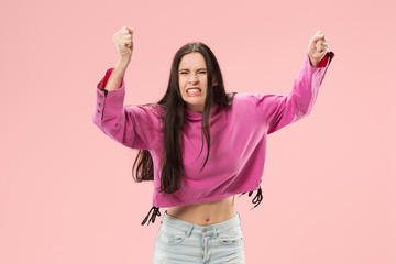 Argue, arguing concept. Beautiful female half-length portrait isolated on pink studio backgroud. Young emotional surprised woman looking at camera.Human emotions, facial expression concept.