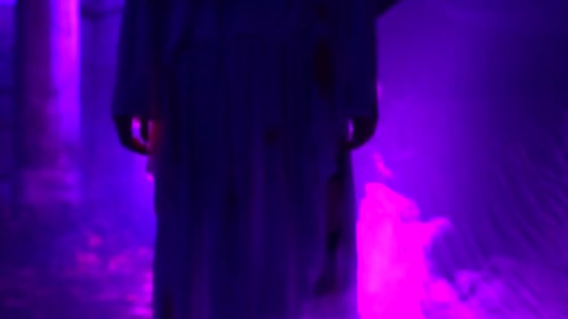 Woman with dead bride make-up for Halloween in the white bride dress in the dark at abandoned house