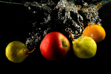 Fototapeta na wymiar Various fruits pear, orange and apple splash of water on black