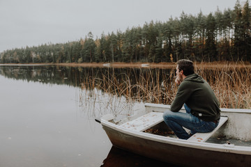 Einsamer Mann im Ruderboot an einem See im Herbst in Schweden / Lonesome Guy In Skiff At Lake...