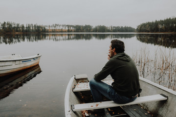 Einsamer Mann im Ruderboot an einem See im Herbst in Schweden / Lonesome Guy In Skiff At Lake...
