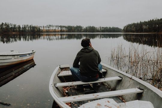 Einsamer Mann im Ruderboot an einem See im Herbst in Schweden / Lonesome Guy In Skiff At Lake During Indian Summer in Sweden
