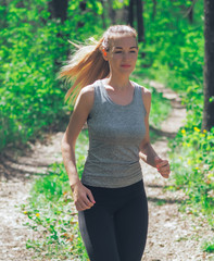 Fototapeta premium Young girl running at the forest happy