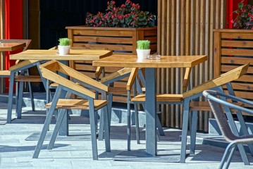 brown wooden table and chairs on the sidewalk outside in the summer cafe