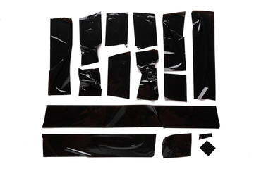 A collection of used black electrical tape pieces isolated on white background