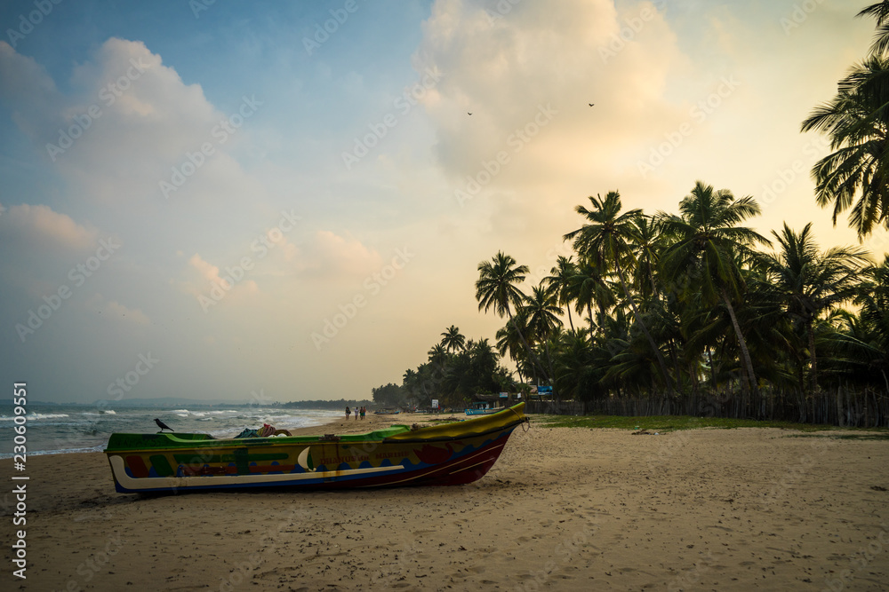 Wall mural boat on a beach at sunset