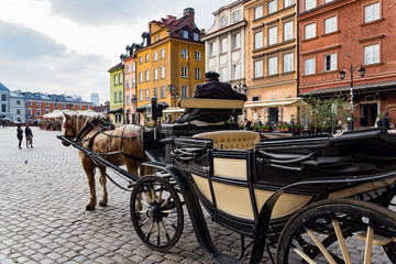 A man with a traditional carriage waits for tourists in the old town of Warsaw, Poland.