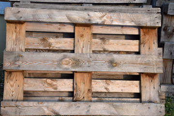 wooden pallets suitable for furniture processing, weathered wooden pallets in a row stored outdoors