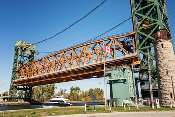 The Burlington Canal Lift Bridge in Hamilton, Ontario, Canada. A vertical-lift bridge over the canal connecting Burlington Bay with Hamilton Harbour on Lake Ontario. In use, with a private vessel.