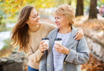 Mother and adult daughter outdoor in park.