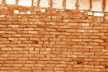 Old grungy brick wall surface in orange tone.