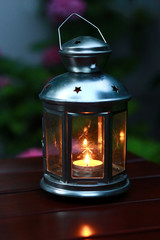 Vintage styled lamp with a candle at night as a background