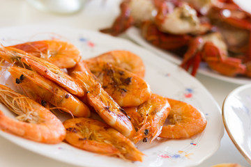 Grilled prawns plate. Fried shrimps appetizer dish. Crab legs on background, seafood dinner concept