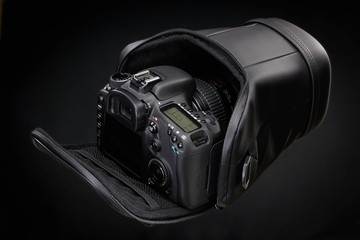 Black DSLR camera isolated on a black background