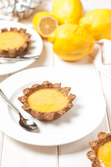 Plate with piece of tasty lemon pie on white wooden table.