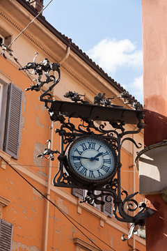 Reloj antiguo en hierro forjado en fachada de edificio. 