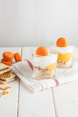 Traditional italian dessert tiramisu with lemon sauce in a glass on a white background.