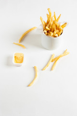 French fries in basket with sauce isolated on white background. Front view.
