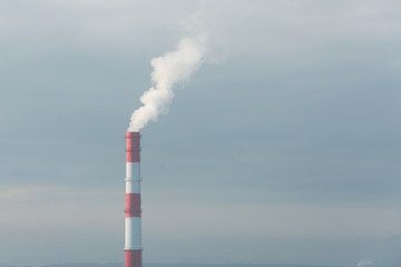 Red and white pipe factory in the polluted atmosphere of the city.