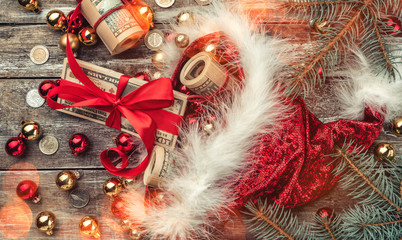 Old wooden Christmas background, Santa Claus, baubles and money coins and Xmas items. Top view....
