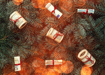 Winter background of fir branches. Money in the form of toys. Christmas card. Top view. Xmas...