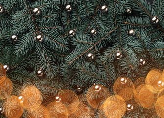Winter background of fir branches. Adorned with gold baubles. Christmas card. Top view. Xmas...