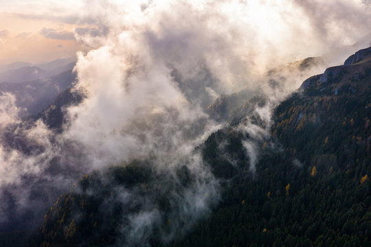 Aerial photography over big mountain forest. Sunset over the forest. Foggy valley at the sunrise. Golden hour over the forest with mist. Beautiful aerial landscape. Drone shots over the foggy forest. © Epic Vision